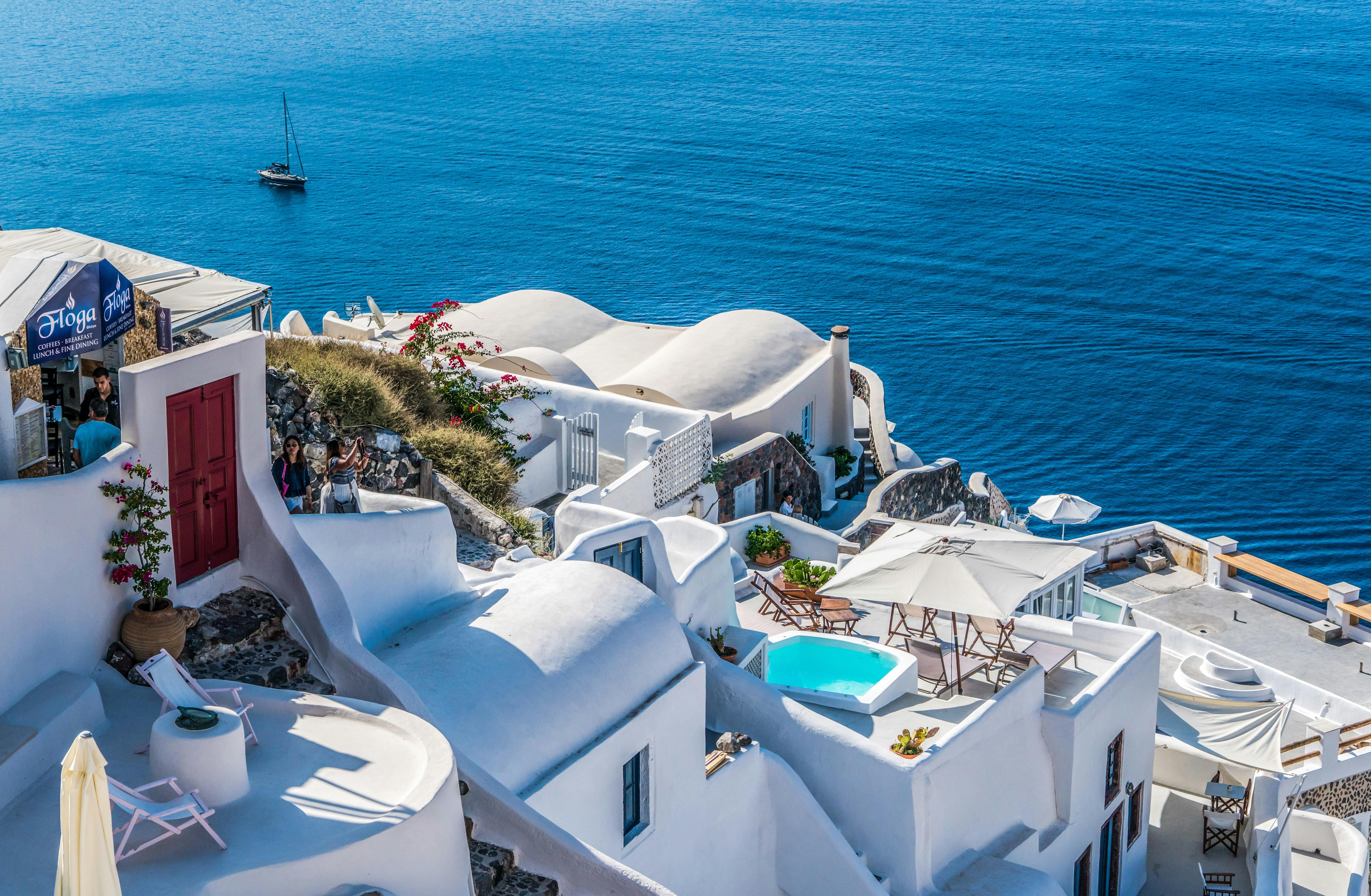 Santorini Greece white buildings with blue domes overlooking the Aegean Sea at sunset